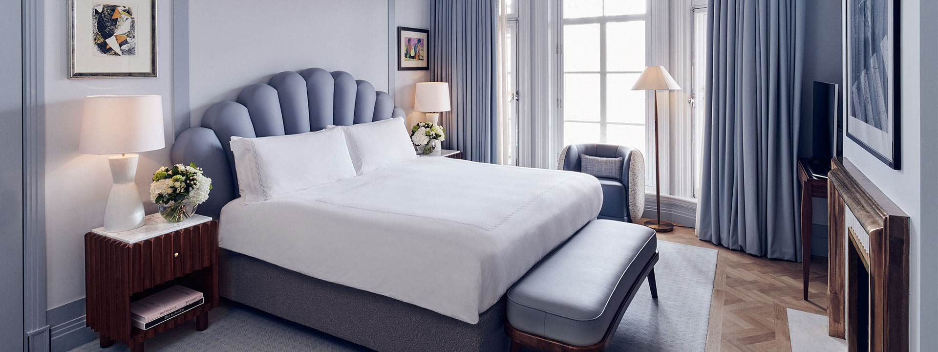 A comfortable King Bed in the Mayfair Terrace Suite, surrounded by elements in pastel blue-grey colours.
