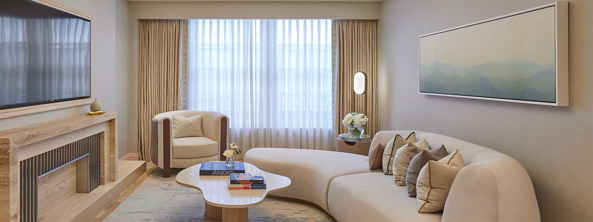 Mayfair suite detail with white couch, design coffee table, armchair and TV