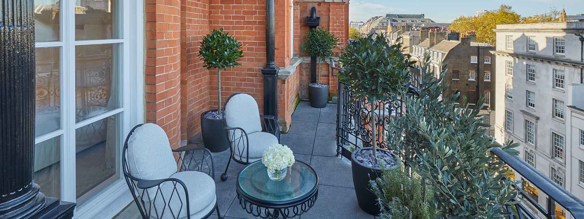 A spacious terrace with comfortable armchairs and a coffee table, which is part of the Mayfair Terrace Suite.