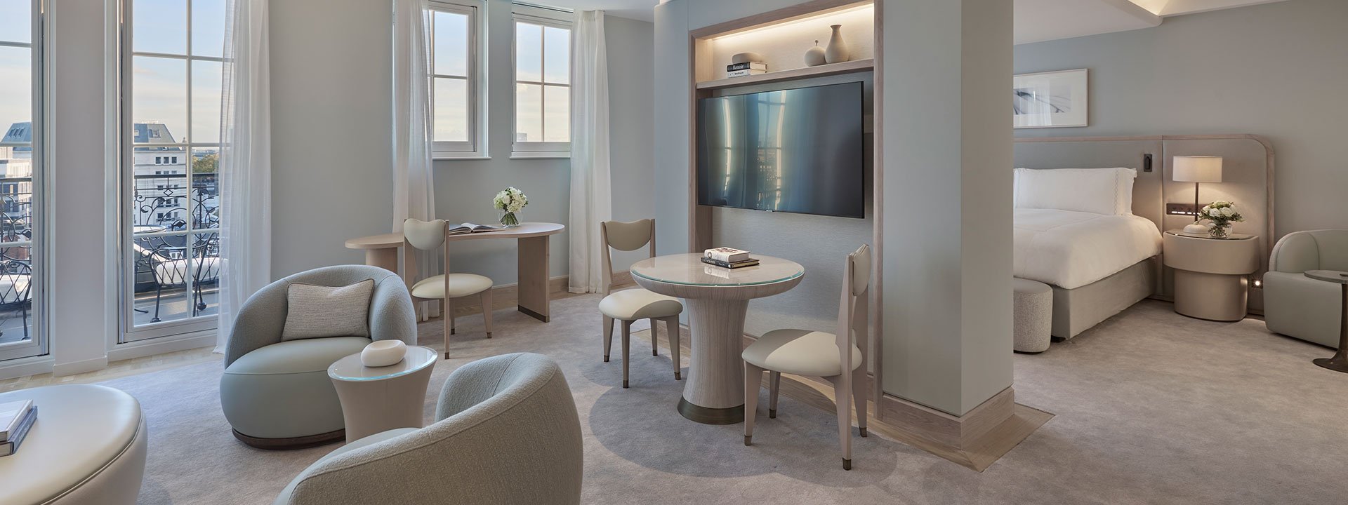 View of the sitting room and part of the bedroom in the Terrace Junior Suite, with furniture in neutral tones.