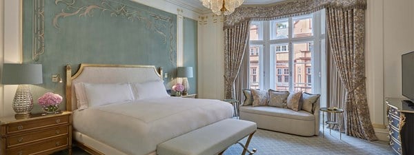 Prince Alexander Suite at Claridge's - bedroom with bed, sofa next to the window and curtains with patterns.