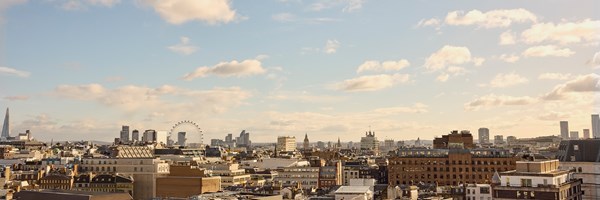 Wide-angle city view of London skyline at golden hour, with iconic landmarks including The Shard, London Eye, and Big Ben.