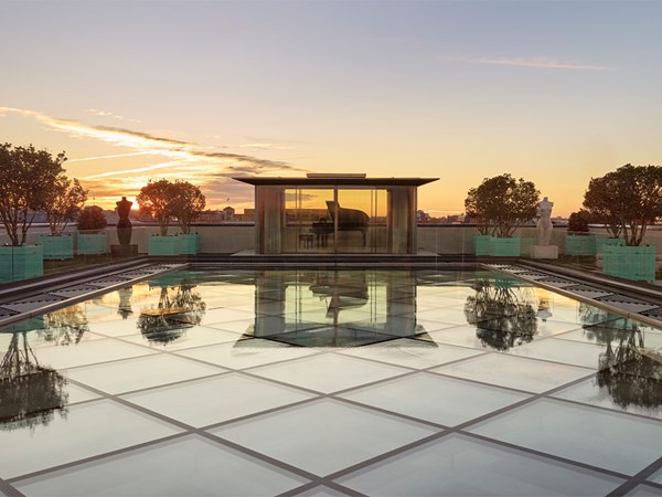 A rooftop terrace with glass flooring at sunset