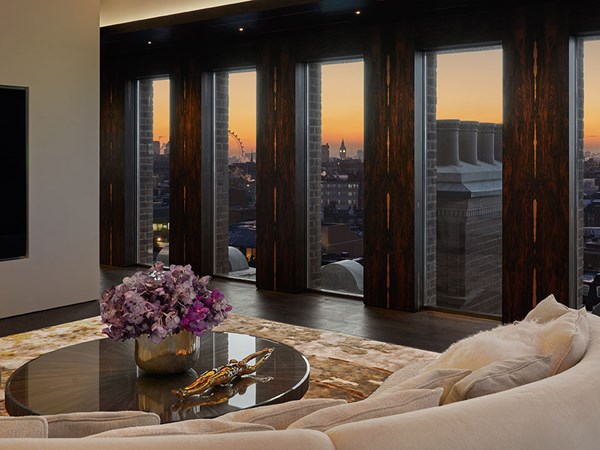 living area with table display with purple flowers overlooking the sunset of the London city skyline