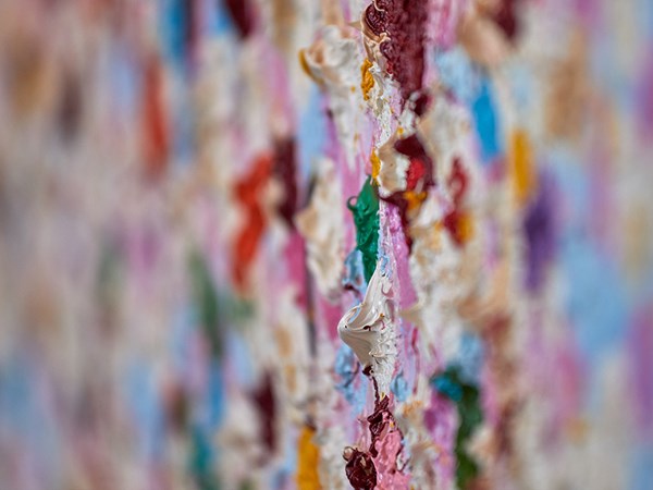 Close up of pink, green, blue, white and red paint strokes on a piece of art