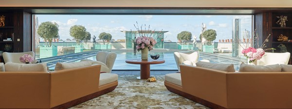 Cream sofas looking out to water feature and glass piano pavilion on rooftop of the Penthouse