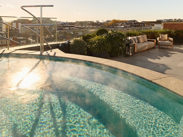 Rooftop pool with city views and outdoor seating.