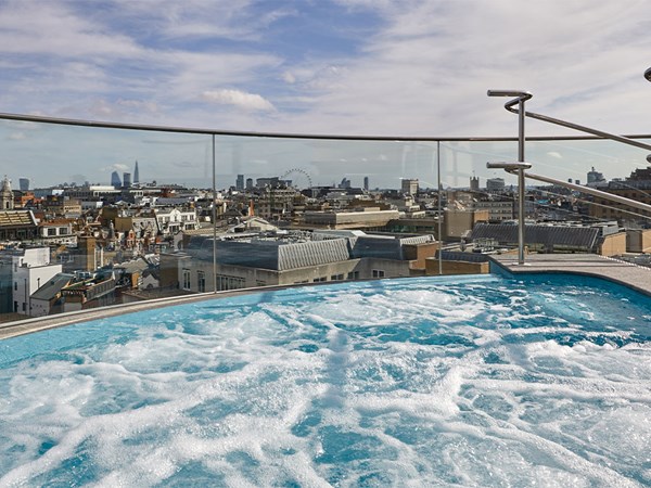 Bubbling hydrotherapy pool outside with London skyline in background