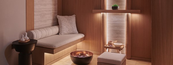 A treatment room at Claridge's Spa. The room is prepared for a guest with a foot bath and comfortable sofa