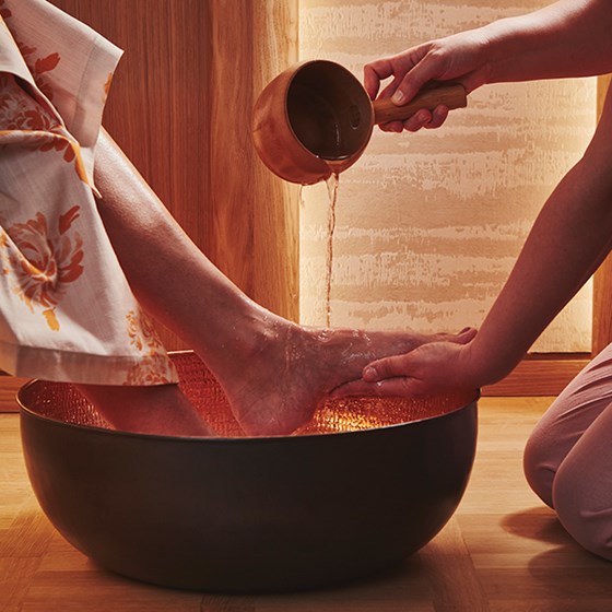 A welcoming foot ritual at Claridge's Spa. A woman's foot is held aloft and water is poured over it.