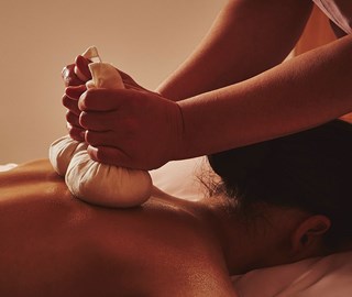 Poultice treatment being performed on woman in spa