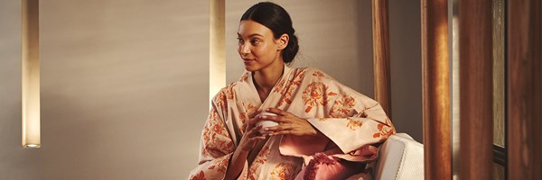 Model wearing a Claridge's Spa kimono and drinking tea in the waiting area