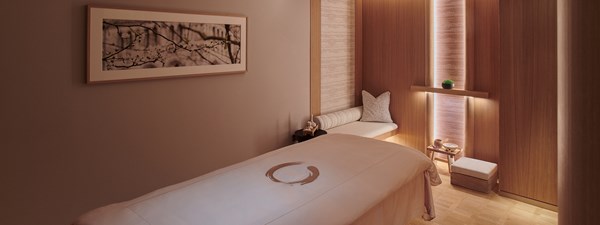 Claridge's Spa - treatment room with bed and art on the wall.