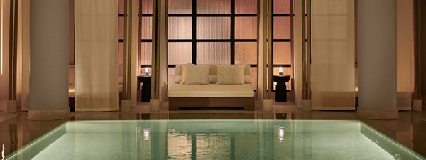 The pool at Claridge's Spa - swimming pool with open cabanas in the background and bed.