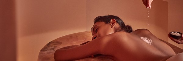 woman having treatment on pink onyx bed