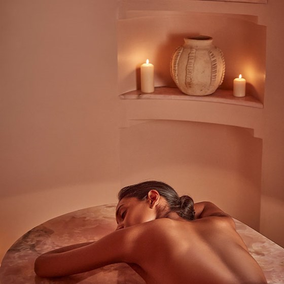 woman having treatment on pink onyx bed