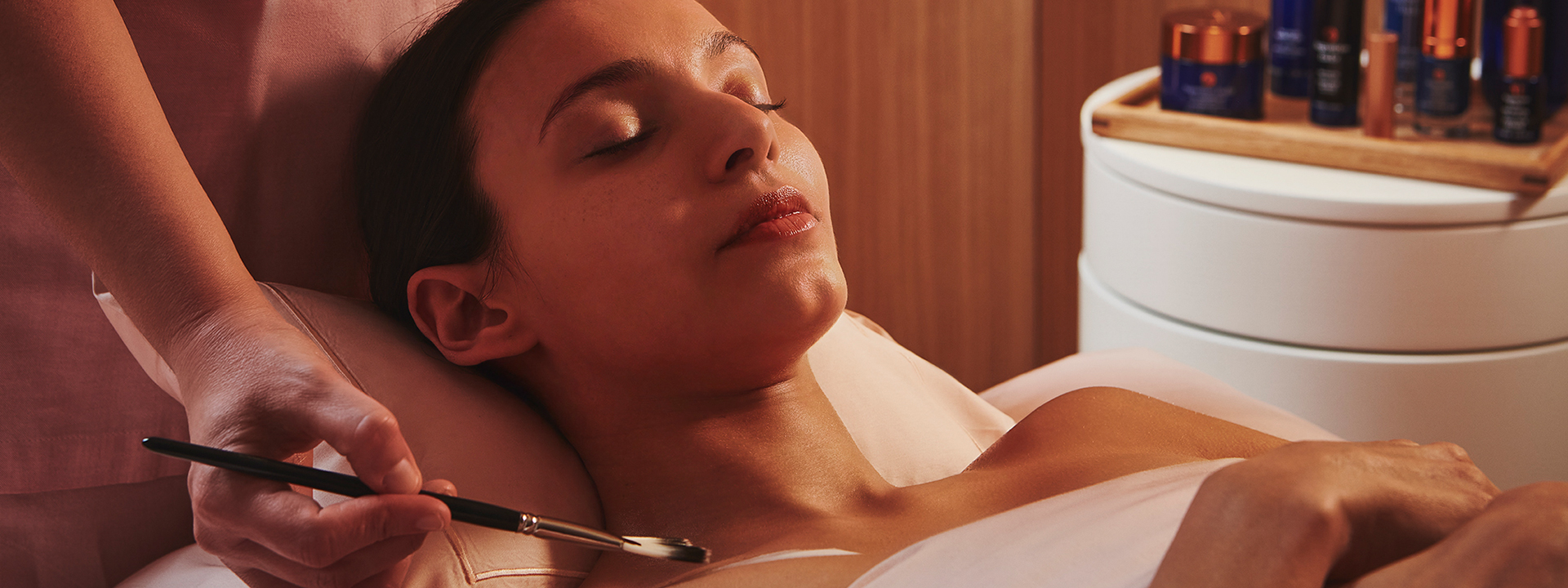 A woman using The Method Augustinus Bader Facial skincare treatment at Claridge's Spa.