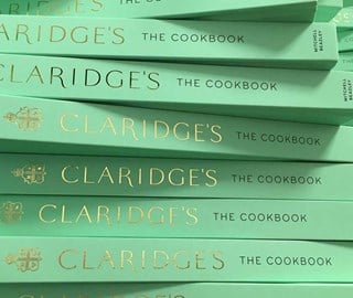 A presentation of Claridge's cookbooks arranged in their mint green colour cover with gold font.